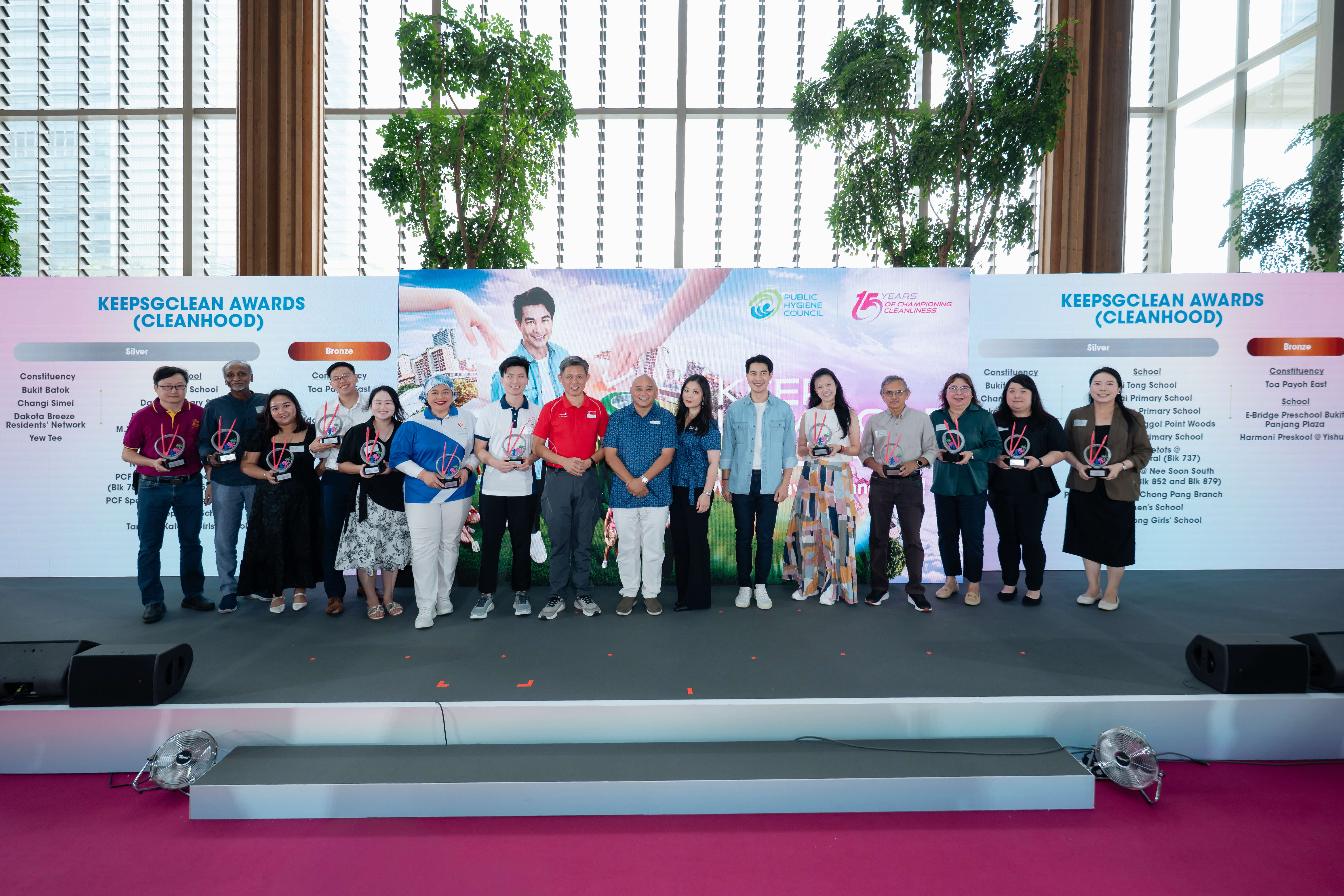 Silver and Bronze award recipients of the KeepSGClean Awards (CleanHood) posing on stage with their trophies at the Keep Singapore Clean 2026 campaign launch, with the list of CleanHood award recipients displayed on both sides of the Public Hygiene Council backdrop.